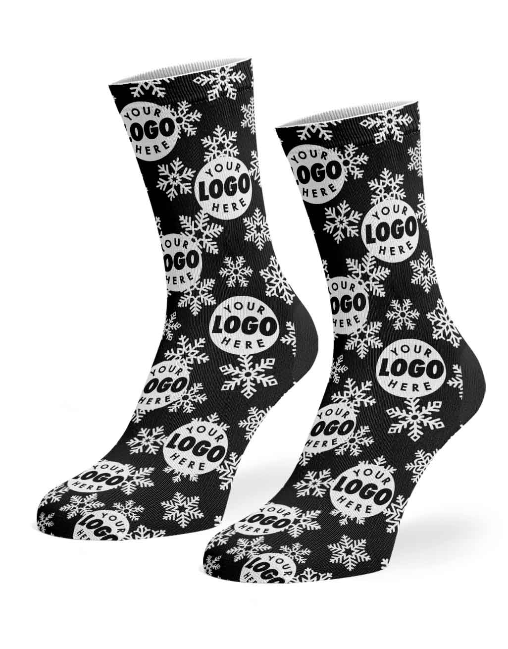 A pair of black crew socks with a white snowflake and circular 'YOUR LOGO HERE' pattern, shown on a clean white background.