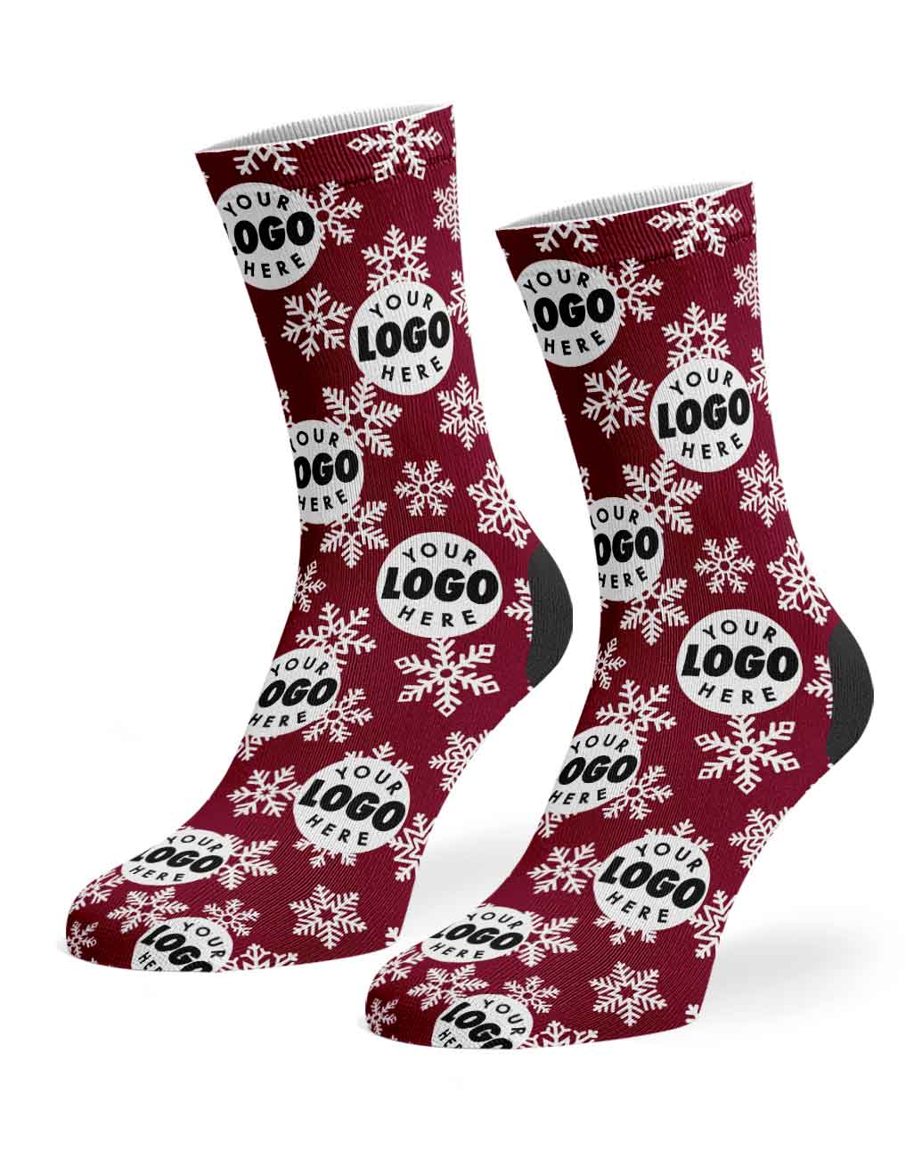 A pair of custom crew socks with a burgundy red background, white snowflakes, and white circular logo placeholders, shown on a clean white background.