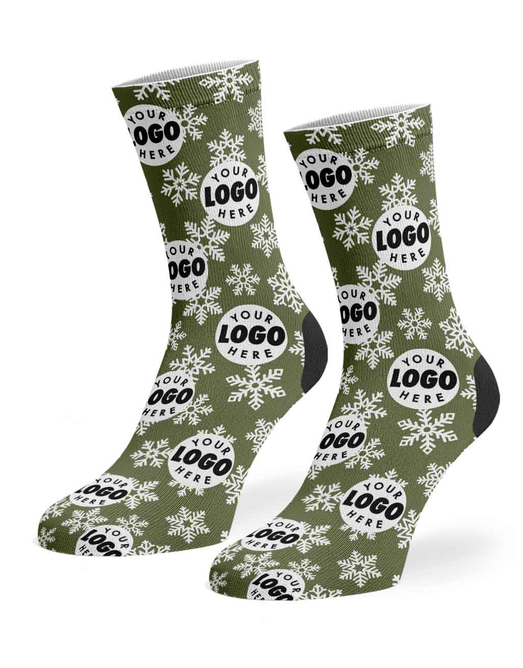 A pair of custom crew socks with an olive green background, white snowflake patterns, and black circular logo placeholders reading 'YOUR LOGO HERE'.